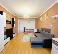 NA PRENÁJOM 2-IZBOVÝ BYT, NÁRODNÁ TRIEDA - Obývacia izba v 2-izbovom byte s podlahou s dreveným dekorom, pohovkou a televízorom.