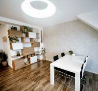 Prenájom moderný a svetlý 3-izbový byt v atraktívnej lokalite - Jedálenský stôl, stoličky a police s dekoračnými prvkami v 3-izbovom byte s podlahou s dreveným dekorom.