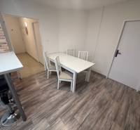 TOPOĽČANY Priestranný 1-izbový byt na prenájom 60 m2 - Jedálenský kút v 1-izbovom byte s podlahou s dreveným dekorom a barovou stoličkou.