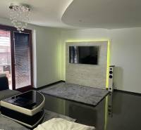 Moderný zariadený rodinný dom na prenájom 120m2 s terasou Košice Barca - Obývacia izba v rodinnom dome s lesklou podlahou a TV na stene.