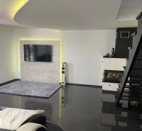 Moderný zariadený rodinný dom na prenájom 120m2 s terasou Košice Barca - Obývacia izba v rodinnom dome so schodiskom, krbom a televíziou na stene.