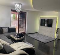 Moderný zariadený rodinný dom na prenájom 120m2 s terasou Košice Barca - Obývačka v rodinnom dome so sedačkou a televízorom na stene s kamenným obkladom.