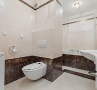 Staré Mesto | 4i byt 175 m² + 4 balkóny + možnosť 2× parking - Kúpeľňa s vaňou, toaletou a práčkou v 4-izbovom byte s obkladmi v zemitých tónoch.