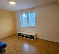 NA PRENÁJOM – PRIESTRANNÝ A SVETLÝ 3-IZBOVÝ BYT V CENTRE GALANTY - Izba s modrou sedačkou, podlahou s dreveným dekorom a bielym nábytkom v 3-izbovom byte.