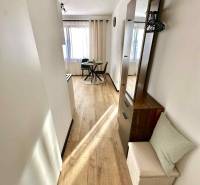 REZERVOVANÝ PREDAJ 1-izbový byt, Vlčince - okr. Žilina - Jasný interiér s jedálenským stolom a podlahou s dreveným dekorom v 1-izbovom byte.