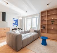 3i BYT V TOP LOKALITE – Trenčín, Sihoť - NA PRENÁJOM - Svetlá obývačka v 3-izbovom byte so sedačkou, dreveným dekorom a modrými doplnkami.