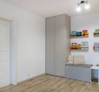 PREDAJ 2 izbový moderne zrekonštruovaný byt s klimatizáciou, CENTRUM - Detská izba s podlahou s dreveným dekorom, skrinkou na stene a knižnými poličkami.