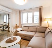 PREDAJ 2 izbový moderne zrekonštruovaný byt s klimatizáciou, CENTRUM - Svetlý obývací priestor v 2-izbovom byte s podlahou s dreveným dekorom a pohodlnou sedačkou.