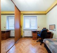 NA PREDAJ 3-izbový byt v centre, jedinečný výhľad na mesto, Nitra - Izba s podlahou s dreveným dekorom, stolom a skriňou v 3-izbovom byte.