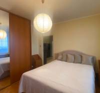 NA PREDAJ 3-izbový byt v centre, jedinečný výhľad na mesto, Nitra - Spálňa v 3-izbovom byte so skriňou, posteľou a podlahou s dreveným dekorom.