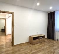 Prenájom komfortný, zariadený 3 izbový byt po úplnej rekonštrukcii - Izba v 3-izbovom byte s podlahou s dreveným dekorom, svetlom a nábytkom.