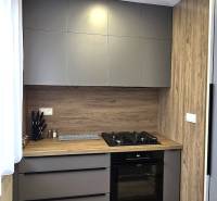 Prenájom komfortný, zariadený 3 izbový byt po úplnej rekonštrukcii - Kuchyňa v 3-izbovom byte s modernými spotrebičmi a podlahou s dreveným dekorom.