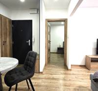 Prenájom komfortný, zariadený 3 izbový byt po úplnej rekonštrukcii - Interiér 3-izbového bytu s podlahou s dreveným dekorom a štýlovým stolom.