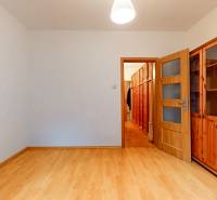 Veľkometrážny 3i byt s výťahom a pivnicou | Ružinov | 82m2 - Izba s podlahou s dreveným dekorom, poličkami a otvorenými dverami v 3-izbovom byte.
