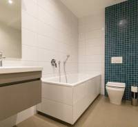 Exkluzívny 2i byt s terasou a parkovaním, Kramáre - Kúpeľňa v 2-izbovom byte s vaňou, umývadlom a zeleným obkladačkovým panelom.