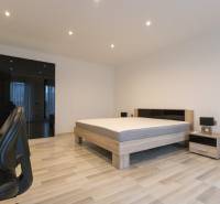 Exkluzívny 2i byt s terasou a parkovaním, Kramáre - 2-izbový byt s podlahou s dreveným dekorom, posteľou, skriňou a kancelárskou stoličkou.