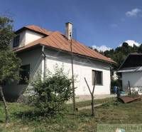 Rodinný dom v srdci Štiavnických vrchov, Štiavnické Bane. - Rodinný dom v Štiavnických Baniach s hnedou strechou obklopený zeleňou a vedľajšou stavbou.