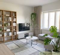 Rodinný dom v srdci Štiavnických vrchov, Štiavnické Bane. - Obývačka v rodinnom dome s poličkou, televízorom a kvetmi; podlaha s dreveným dekorom.