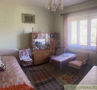 Rodinný dom v srdci Štiavnických vrchov, Štiavnické Bane. - Obývačka v rodinnom dome s pohovkou, vitrínou, kreslom a kobercom.