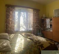 Rodinný dom v srdci Štiavnických vrchov, Štiavnické Bane. - Spálňa v rodinnom dome s posteľou, skrinkou a dekoračnými závesmi.