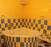 Nebytový priestor, Mikulášska, centrum mesta pod hradom - Na fotografii je žltá kúpeľňa s rohovou vaňou a farebnými obkladmi.