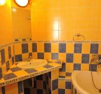 Nebytový priestor, Mikulášska, centrum mesta pod hradom - Kúpeľňa s oranžovo-modrými kachličkami, umývadlom a vaňou, v 1-izbovom byte na ulici Mikulášska.