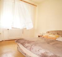 Rodinný dom v obci Čilížska Radváň s veľkým pozemkom - Spálňa v rodinnom dome, osvetlená oknom, s posteľou a radiátorom.