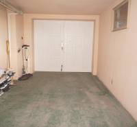 Rodinný dom v obci Čilížska Radváň s veľkým pozemkom - Garáž v rodinnom dome s bledými stenami, policou na topánky a bicyklom.