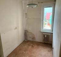 4-izb. byt, Martinčekova ul., Ružinov, 2.p./10, 2 x lodžia - Malá izba s podlahou s dreveným dekorom, poškodené steny a radiátor v 4-izbovom byte.