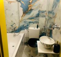 Garzónka M. Schneidra Trnavského, Dúbravka, veľká lodžia - Kúpeľňa v garsónke s vaňou a mramorovým umývadlom, obklady s modro-zlatým vzorom.