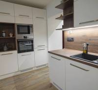 2,5 izb. byt, ul. Jelenia, Staré Mesto,tehlový dom, po rekonštrukcii - Kuchyňa s bielymi skrinkami, drevenou pracovnou doskou, vstavanými spotrebičmi v 3-izbovom byte na ulici Jelenia.