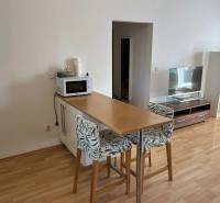 3-izb. byt, Palkovičova ul., Ružinov, lodžia, 4.p./12 - Kuchynský kút 3-izbového bytu s barovým pultom, stoličkami a podlahou s dreveným dekorom.