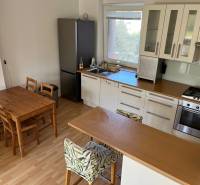 3-izb. byt, Palkovičova ul., Ružinov, lodžia, 4.p./12 - Kuchyňa s jedálenským stolom v 3-izbovom byte, podlaha s dreveným dekorom.