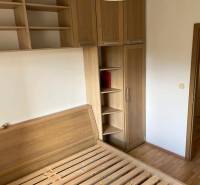 3-izb. byt, Palkovičova ul., Ružinov, lodžia, 4.p./12 - Spálňa v 3-izbovom byte s posteľou, skriňami a podlahou s dreveným dekorom.