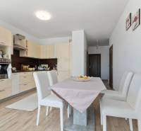 Novostavba 3-izb. bytu s parkovacím státím, ul.Hany Ponickej, Lamač - Kuchyňa v 3-izbovom byte s podlahou s dreveným dekorom a jedálenským stolom.