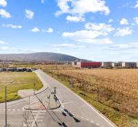 Novostavba 3-izb. bytu s parkovacím státím, ul.Hany Ponickej, Lamač - Cesta a polia vo štvrti Bratislava - Lamač, Hany Ponickej, obklopené budovami.