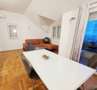 Chorvátsko, Makarska - zariadený apartmán s výhľadom na more - Jedáleň a obývačka v rekreačnom apartmáne s podlahou s dreveným dekorom.