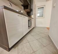 Chorvátsko, Makarska - zariadený apartmán s výhľadom na more - Kuchyňa v rekreačnom apartmáne s dlažbou a modernou linkou s tmavými skrinkami.