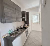 Chorvátsko, Makarska - zariadený apartmán s výhľadom na more - Kuchyňa Rekreačného apartmánu s moderným vybavením a oknom, ktoré osvetľuje priestor.