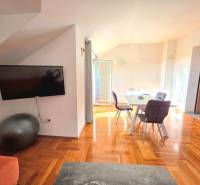 Chorvátsko, Makarska - zariadený apartmán s výhľadom na more - Interiér rekreačného apartmánu s podlahou s dreveným dekorom a jedálenským stolom.