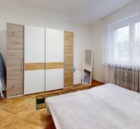 Priestranný 3 izbový byt s dvomi balkónmi, BA III. Kramáre, Stromová - Spálňa s posteľou, skriňou s dreveným dekorom a veľkým oknom v 3-izbovom byte.