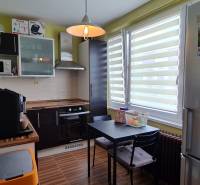 Predaj 2i byt v meste Kremnica, 64m2 - Kuchyňa v 2-izbovom byte s tmavou linkou a podlahou s dreveným dekorom.