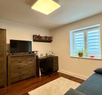 Rodinný dom v Bratislave – Podunajské Biskupice - Domáca pracovňa s televízorom, písacím stolom, kreslom a podlahou s dreveným dekorom.