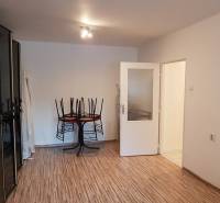 PREDAJ 2 IZBOVÝ BYT HANDLOVÁ  - Obývacia izba s drevenou podlahou, stolom a stoličkami v 2-izbovom byte.