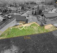 Stavebný pozemok lokalita Slnečná úboč, Levočská Dolina, okres Levoča - Pozemky - bývanie v Levoči, šikmá zelená parcela na svahovitom prostredí medzi domami.