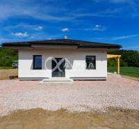 EXKLUZÍVNE: Novostavba 4i bungalov, obec Harichovce, okres Sp. Nová Ve - Rodinný dom v Harichovciach s bielou fasádou a drevenou pergolou na vidieku.