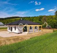EXKLUZÍVNE: Novostavba 4i bungalov, obec Harichovce, okres Sp. Nová Ve - Rodinný dom v Harichovciach obklopený zeleňou, s bagerom na pozemku.