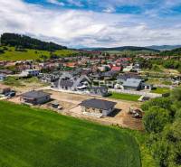 EXKLUZÍVNE: Novostavba 4i bungalov, obec Harichovce, okres Sp. Nová Ve - Letecký pohľad na rodinné domy v Harichovciach, obklopené prírodou a zástavbou.