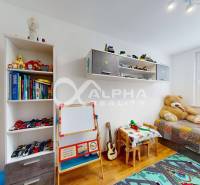 EXKLUZÍVNE 3i byt s loggiou, Spišské Podhradie - Detská izba v 3-izbovom byte s posteľou, hračkami, knihami a podlahou s dreveným dekorom.