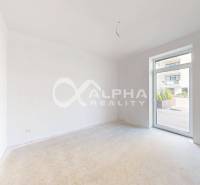 3i byty s balkónom, terasou, garážovým státím, Zelené údolie, Sp. Nová - Priestranná izba s bielymi stenami a veľkými oknami v 3-izbovom byte.